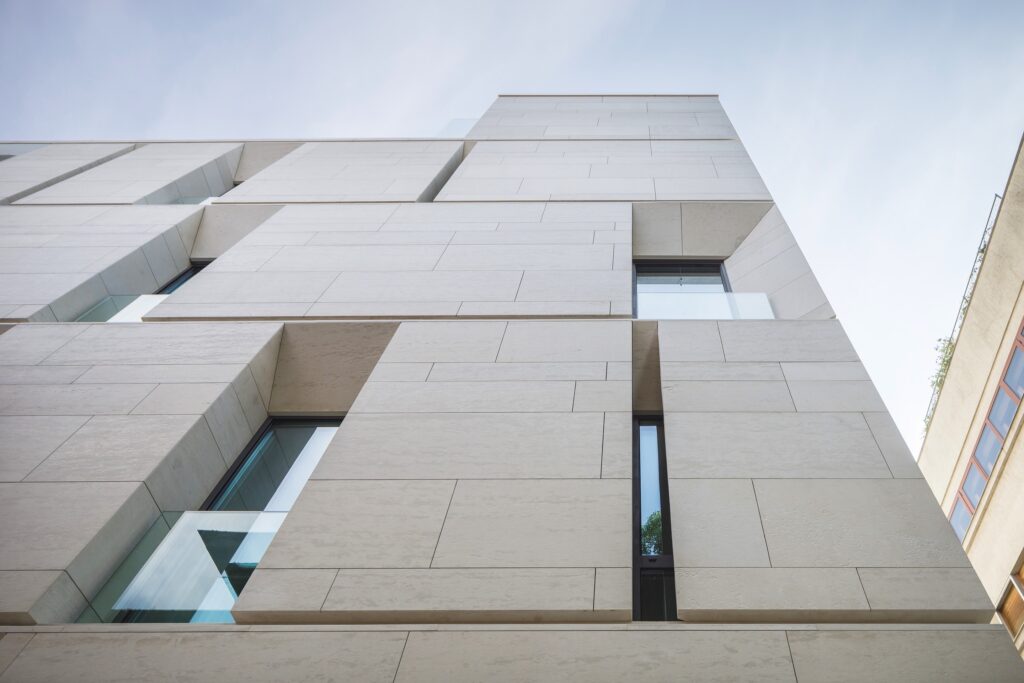 Modern geometric limestone facade with angled window reveals